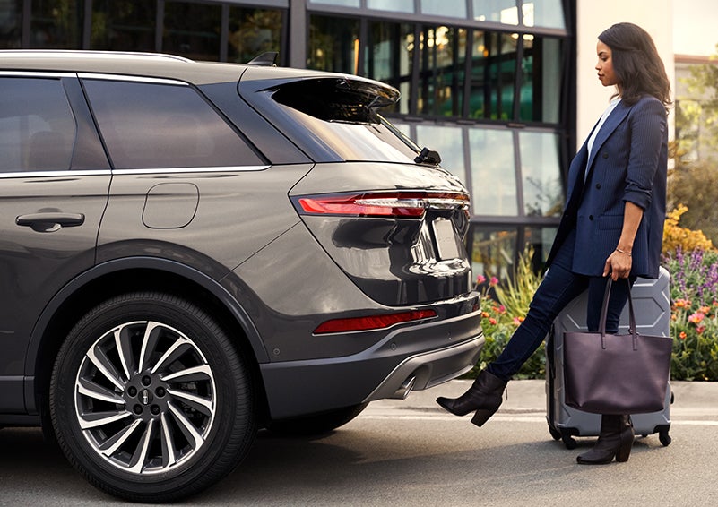 A woman with her hands full uses her foot to activate the available hands-free liftgate. | Lincoln Demo 4 in Derwood MD