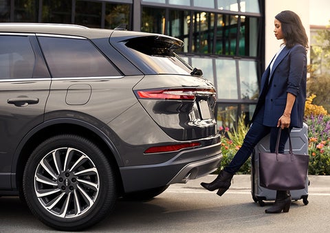 A woman with her hands full uses her foot to activate the available hands-free liftgate. | Lincoln Demo 4 in Wooster OH