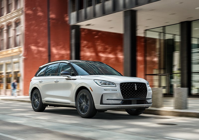 The 2024 Lincoln Corsair® SUV with the Jet Appearance Package and a Pristine White exterior is parked on a city street. | Lincoln Demo 4 in Wooster OH