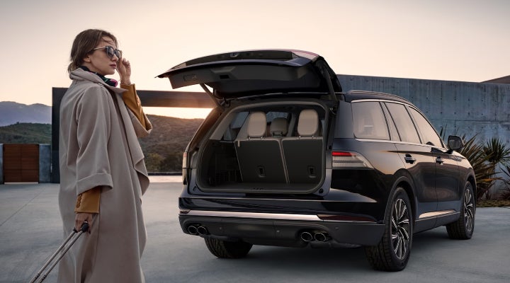 A woman approaches a 2026 Lincoln Aviator® SUV with its rear liftgate open. | Lincoln Demo 4 in Derwood MD